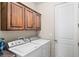 Laundry room featuring white appliances, custom cabinetry and a door to the side at 1428 Chaparral Dr, Mesquite, NV 89027