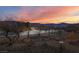 Street view showcasing desert landscaping with mountain views at sunset at 1428 Chaparral Dr, Mesquite, NV 89027