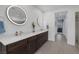Modern bathroom with dual sinks, hardwood cabinets, and walk-in shower at 1945 Canyon Highlands Dr, Henderson, NV 89052