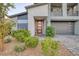 Contemporary two-story home featuring a modern front door, well-maintained landscaping, and a gray paved driveway at 1945 Canyon Highlands Dr, Henderson, NV 89052
