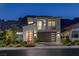 Modern two-story home with a minimalist design, balcony, desert landscaping and mountain views at twilight at 1945 Canyon Highlands Dr, Henderson, NV 89052