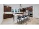 Modern kitchen featuring dark wood cabinets, granite countertops, and stainless steel appliances, including seated island at 1945 Canyon Highlands Dr, Henderson, NV 89052