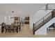 Bright dining room leading to kitchen, featuring a staircase with metal railing and neutral colors at 1945 Canyon Highlands Dr, Henderson, NV 89052