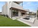 Beautiful backyard featuring a modern home, pool, hot tub, turf, and covered patio at 21 Grey Owl Ct, Las Vegas, NV 89135