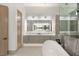 Spa-like bathroom featuring a soaking tub, marble shower, dual sinks, and modern lighting at 21 Grey Owl Ct, Las Vegas, NV 89135
