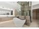 Elegant bathroom with a sleek soaking tub, glass shower enclosure, and stylish vanity with modern fixtures at 21 Grey Owl Ct, Las Vegas, NV 89135
