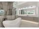 Elegant bathroom with a soaking tub, glass shower, dual vanities, and modern light fixtures at 21 Grey Owl Ct, Las Vegas, NV 89135
