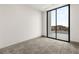 Minimalist bedroom with sliding glass doors to balcony and neutral carpet at 21 Grey Owl Ct, Las Vegas, NV 89135