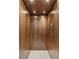 Modern elevator featuring wood paneling, recessed lighting, and sleek control panel at 21 Grey Owl Ct, Las Vegas, NV 89135