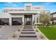 Contemporary home with manicured landscaping, glass paneled garage doors, and a walkway leading to a modern entrance at 21 Grey Owl Ct, Las Vegas, NV 89135