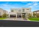 Contemporary two-story home with modern curb appeal, featuring a manicured lawn, and glass paneled garage doors at 21 Grey Owl Ct, Las Vegas, NV 89135