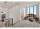 Upstairs hallway with seating area, stylish rug, large windows, and modern railing at 21 Grey Owl Ct, Las Vegas, NV 89135