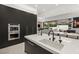 Modern kitchen boasts sleek black cabinetry, stainless steel appliances, and a spacious island with white countertops at 21 Grey Owl Ct, Las Vegas, NV 89135