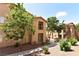 Exterior of a tan apartment building featuring landscaped grounds and second story patios at 2110 Los Feliz St # 2052, Las Vegas, NV 89156