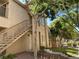 Exterior of a tan apartment building featuring an outdoor staircase and ample greenery at 2110 Los Feliz St # 2052, Las Vegas, NV 89156
