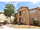 Exterior of a tan apartment building featuring outdoor staircases and a neatly landscaped yard at 2110 Los Feliz St # 2052, Las Vegas, NV 89156