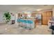 Open kitchen boasts wood cabinets, granite counters and breakfast bar with teal stools at 2690 S Dandelion St, Pahrump, NV 89048