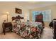 Cozy bedroom with a floral comforter, lamps, and wood furniture at 3055 Key Largo Dr # 203, Las Vegas, NV 89120