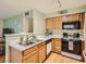 Galley kitchen with wood cabinets and appliances at 3055 Key Largo Dr # 203, Las Vegas, NV 89120
