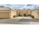 Front view of tan stucco house with arched entryway at 448 Wonderstone Dr, Las Vegas, NV 89107