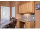 Built-in granite desk with light wood cabinets and gray tile backsplash at 479 Via Ventana Dr, Mesquite, NV 89027