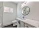 Modern bathroom with a round mirror and a white marble vanity at 4871 Charlemagne Ave, Las Vegas, NV 89130