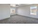 Bright bedroom featuring neutral carpet, modern light fixture, and multiple windows at 4871 Charlemagne Ave, Las Vegas, NV 89130