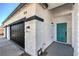 Close-up of the exterior showcasing the 3-car garage and the front door with manicured yard at 4871 Charlemagne Ave, Las Vegas, NV 89130