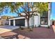 Two-story home with a three-car garage, desert landscaping and a well-manicured tree in the yard at 4871 Charlemagne Ave, Las Vegas, NV 89130