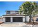 Two-story home showcasing a well-maintained lawn, black garage doors, and a neutral color scheme at 4871 Charlemagne Ave, Las Vegas, NV 89130