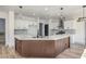 Contemporary kitchen featuring a sleek island with a waterfall countertop and modern pendant lighting at 4871 Charlemagne Ave, Las Vegas, NV 89130