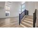 Bright living room showcases wood-look floors and a staircase with a dark handrail at 4871 Charlemagne Ave, Las Vegas, NV 89130