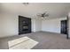 Expansive living room boasts a fireplace with black accent wall, carpet, and a ceiling fan at 4871 Charlemagne Ave, Las Vegas, NV 89130