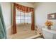Bathroom featuring garden tub, tiled walls, window with valance and a toilet with decorative accessories at 5105 Kingsbridge Dr, Las Vegas, NV 89130