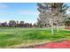 Green golf course with mature trees and red dirt at 5105 Kingsbridge Dr, Las Vegas, NV 89130