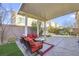 Backyard patio features red outdoor furniture, stone flooring, and manicured landscaping at 5988 Pirates Delight Ave, Las Vegas, NV 89139