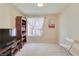 This bedroom features carpet, a window with sheer curtains, a bookshelf, and a chair at 5988 Pirates Delight Ave, Las Vegas, NV 89139