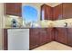 A kitchen with a large arching window showing an outdoor view, as well as dark wood cabinets at 5988 Pirates Delight Ave, Las Vegas, NV 89139