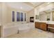 Bright bathroom with soaking tub, fireplace, and decorative tile surround at 6425 Orto Botanico Ct, Las Vegas, NV 89131