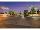 Inviting entrance to Hidden Canyon Estates with lush landscaping and palm trees at dusk at 6425 Orto Botanico Ct, Las Vegas, NV 89131