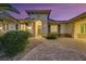 Inviting front entrance with a brick walkway, complemented by beautiful landscaping and a decorative green door at 6425 Orto Botanico Ct, Las Vegas, NV 89131