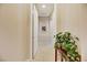 Hallway featuring tile flooring, decorative plants, and view of other rooms through an arched doorway at 6425 Orto Botanico Ct, Las Vegas, NV 89131