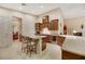 Modern kitchen with island, bar seating, wine fridge, tile floors, stainless appliances, and wood cabinetry at 6425 Orto Botanico Ct, Las Vegas, NV 89131