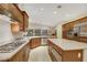 Spacious kitchen featuring granite counters, stainless appliances, gas cooktop, tile floors, and wood cabinetry at 6425 Orto Botanico Ct, Las Vegas, NV 89131