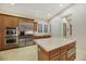 Updated kitchen boasts stainless appliances, large island, double ovens, tile flooring, and wood cabinets at 6425 Orto Botanico Ct, Las Vegas, NV 89131