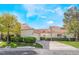 Charming home with a red tile roof, well-maintained landscaping, and a lush green lawn under a sunny, blue sky at 6914 Emerald Springs Ln, Las Vegas, NV 89113