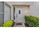 Welcoming front door with sidelight, surrounded by lush greenery and a stylish welcome mat at 6914 Emerald Springs Ln, Las Vegas, NV 89113