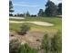 Scenic golf course view featuring lush green grass, mature trees, and sand traps at 6914 Emerald Springs Ln, Las Vegas, NV 89113