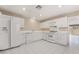 Bright kitchen features white appliances, tiled floors, and plenty of cabinet space for storage at 6914 Emerald Springs Ln, Las Vegas, NV 89113
