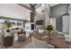 Open-concept living room with a fireplace, modern furniture, and views of the outdoors at 6914 Emerald Springs Ln, Las Vegas, NV 89113